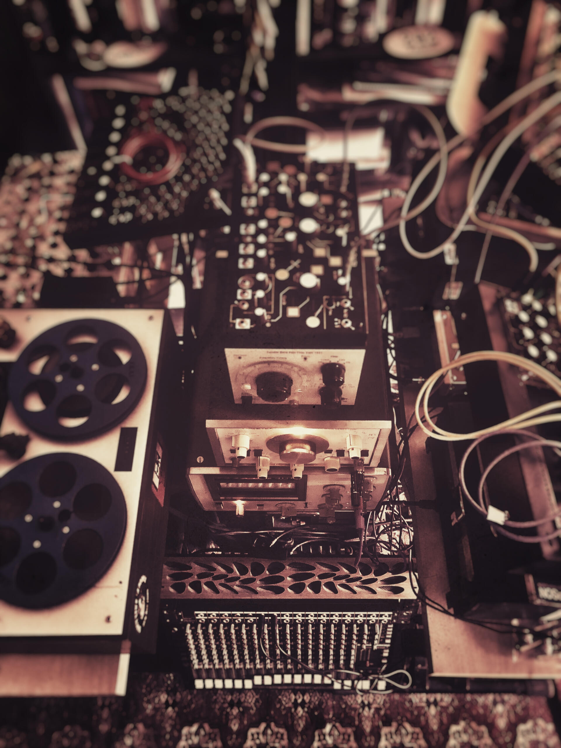 Studio A view from above of music studio equipment. Lots of gizmos with buttons, dials and cables going everywhere.